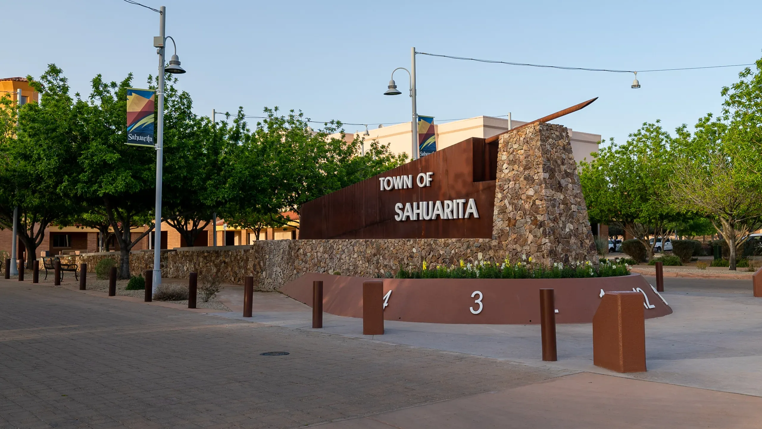 The Town of Sahuarita stone entry monument beneath shade trees on a sunny morning